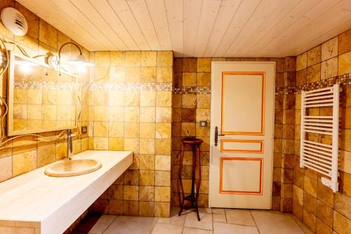 a bathroom with a sink and a door at La Ferme D'estafinette in Redortiers
