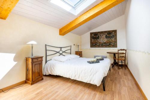 a bedroom with a bed with a teddy bear on it at La Ferme D'estafinette in Redortiers