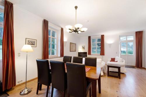 a dining room and living room with a table and chairs at Gut Rattelvitz, Parterre A OST in Gingst