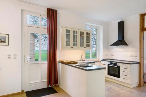 a kitchen with white cabinets and a black counter top at Gut Rattelvitz, Parterre A OST in Gingst