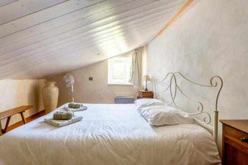 a bedroom with a white bed with a wooden ceiling at Mas des Oliviers in Redortiers