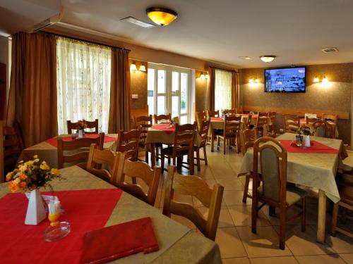 een restaurant met tafels en stoelen en een tv aan de muur bij Casa Belazur in Deva