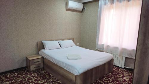 a small bed in a room with a window at Sitora in Chirchiq