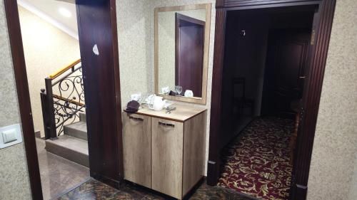 a bathroom with a sink and a mirror and a staircase at Sitora in Chirchiq