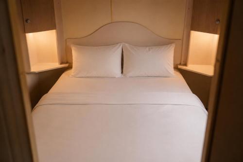a bedroom with a bed with white sheets and pillows at Chalet Ardennen The Great Hill in Amblève