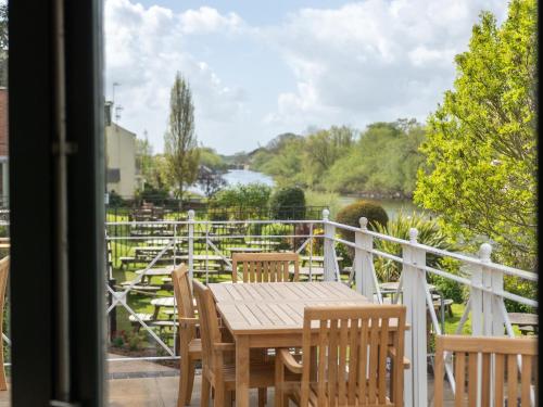 a table and chairs on a balcony with a view of a river at Diglis House Hotel in Worcester