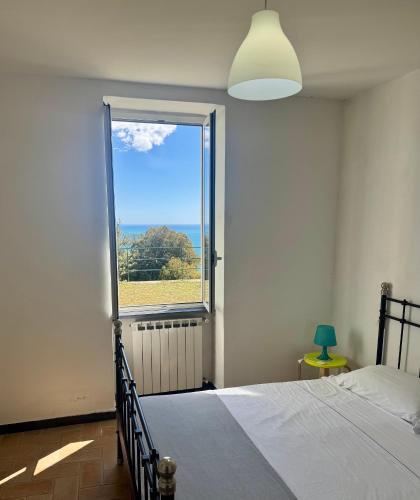 a bedroom with a bed and a large window at Rossola House in Bonassola