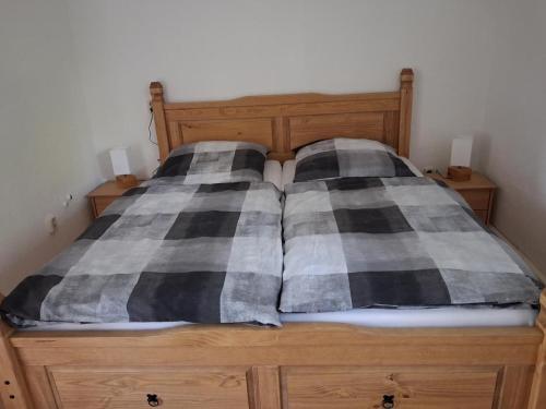a bed with black and white pillows on it at NEU! See-Ferienwohnung 3 in Großmöhlau