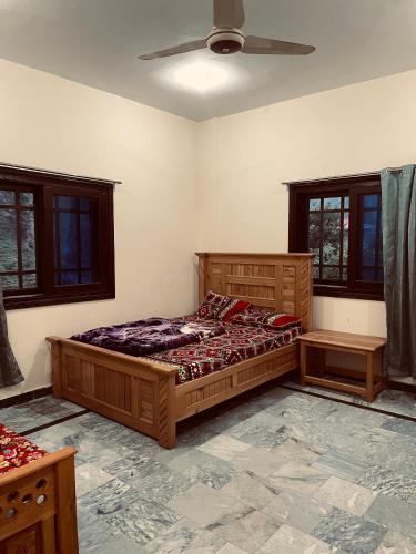 a bedroom with two beds and a ceiling fan at Rayn Basayra Kashmir in Bāta