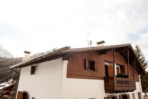 a house with a wooden roof and a balcony at Casa Remo 1 in San Vito di Cadore