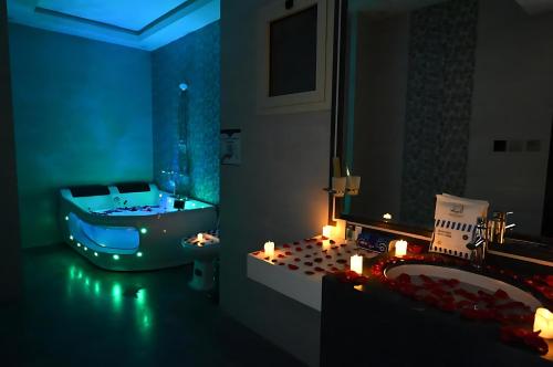 a bathroom with a tub and a sink with candles at فندق ان فيولا in Jazan
