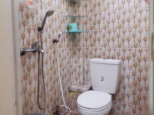 a small bathroom with a toilet and a shower at Quattrick Dee Homestay Mitra RedDoorz in Manokwari