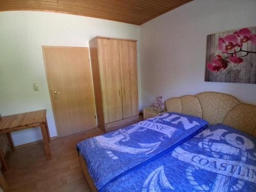 a bedroom with a bed with a blue comforter at NEU! See-Ferienwohnung 4 in Großmöhlau