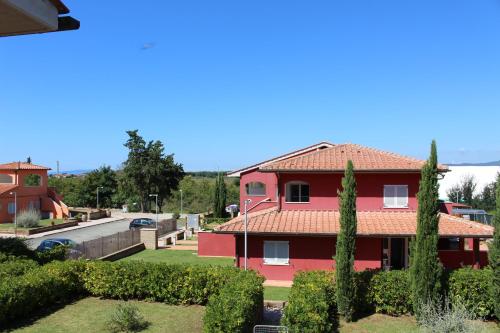 a red house with a red roof at Aba Village RTA in Puntone di Scarlino