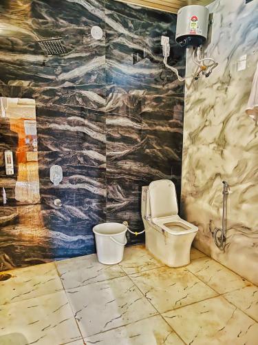a bathroom with a toilet in the corner of a room at Geetanjali hotel and resort in Udaipur