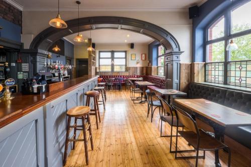 um bar com mesas e cadeiras de madeira num restaurante em The Wellington em Bristol