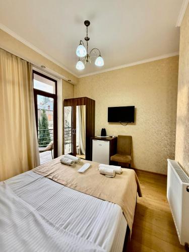 a bedroom with a large bed and a television at Hotel Vera View in Tbilisi City