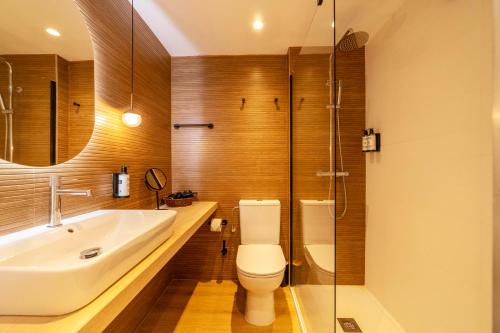a bathroom with a toilet and a sink and a shower at Flacalco Hotel & Apartments in Cala Ratjada