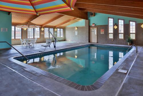 una piscina con sombrilla en un edificio en Sauk River Inn & Suites, a Travelodge by Wyndham, en Sauk Centre