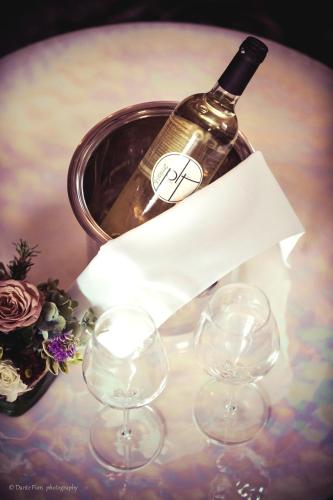 a bottle of wine and three wine glasses on a table at Podere La Torre in Schio