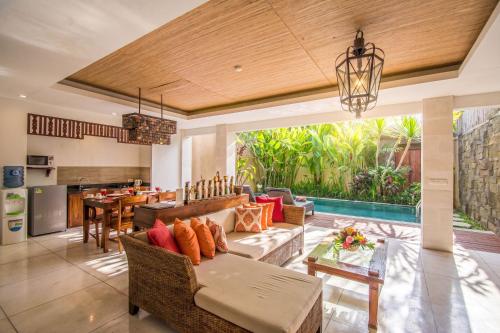 an open living room with a couch and a table at Kamajaya Villas in Ubud