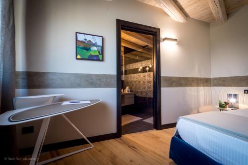a bedroom with a bed and a desk and a bathroom at Podere La Torre in Schio