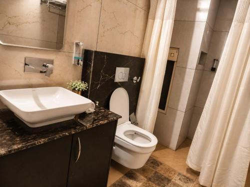 a bathroom with a white toilet and a sink at Sanctuary Boutique Hotel in Bhīm Tāl
