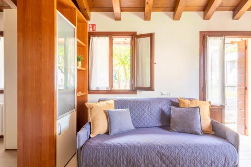 a blue couch in a living room with windows at TRAIN HOUSE in Treviso