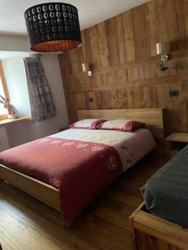 a bedroom with a large bed with a wooden wall at Lo Péyo Avise in Avise