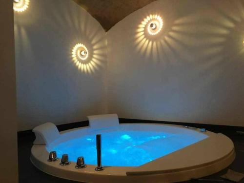 ein Badezimmer mit Badewanne und Wandbeleuchtung in der Unterkunft Lo Bòi Avise in Avise
