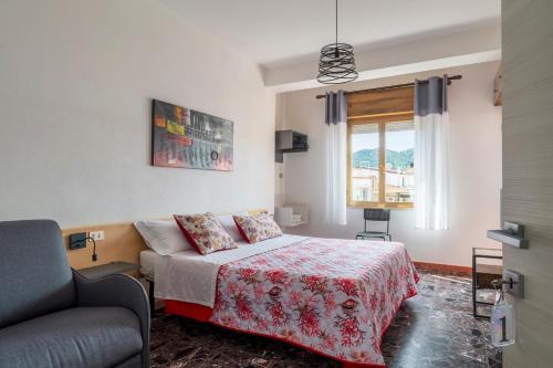 a bedroom with a bed and a couch and a window at B&B Cardedu in Cardedu
