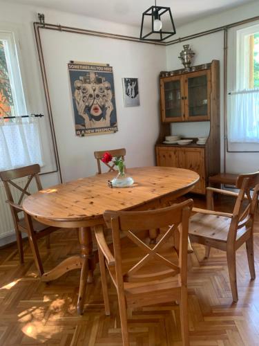 a dining room with a wooden table and chairs at Tūlevél/Pine-needles in Tata