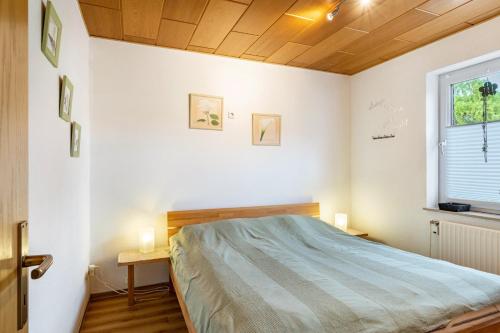 a bedroom with a bed and a window at Ferienwohnung Henrich in Hooksiel