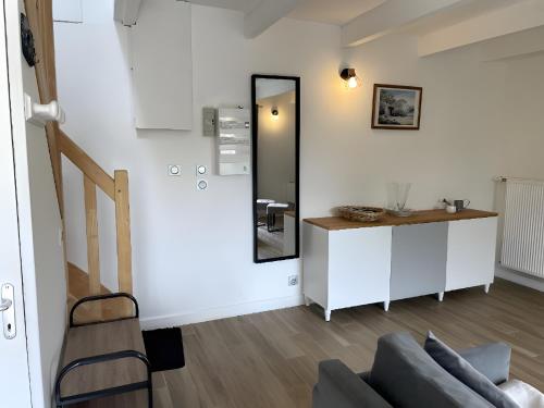 a living room with a couch and a mirror at Gite Baie 3km plages in Telgruc-sur-Mer