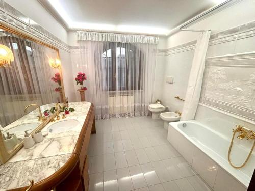 a bathroom with a tub and a sink and a toilet at Villa Felicità in Lucca