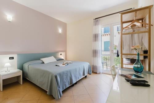 a bedroom with a bed and a table and a window at Cerri Hotel in Castellammare del Golfo
