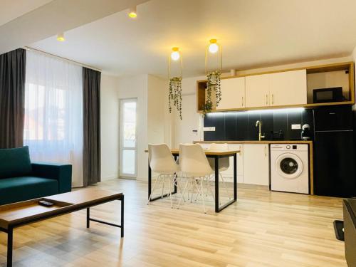 a kitchen and living room with a table and chairs at Vila Morariu in Bistriţa