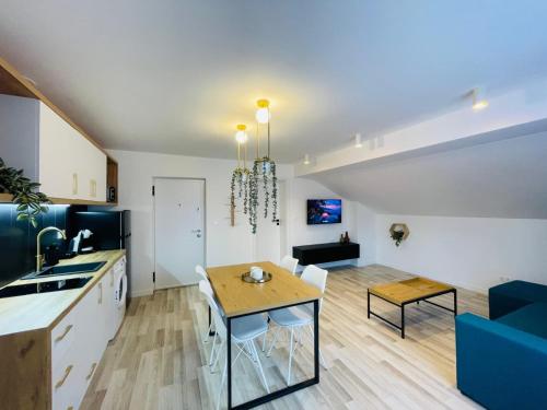 a kitchen and living room with a table and a dining room at Vila Morariu in Bistriţa