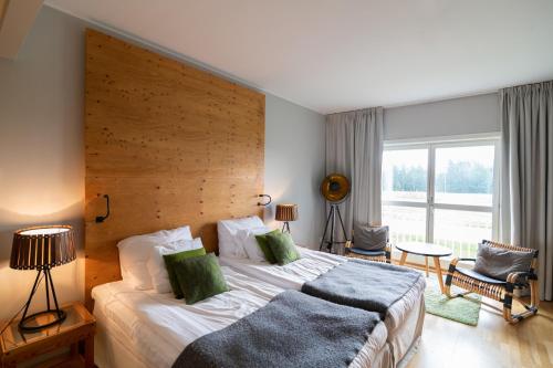 a bedroom with a large bed and a large window at Selma Spa in Sunne