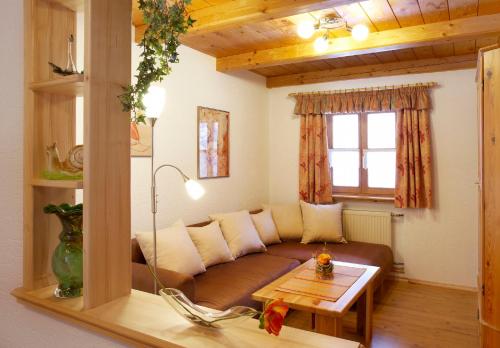ein Wohnzimmer mit einem Sofa und einem Tisch in der Unterkunft Ferienhaus Bärenhöhle in Spiegelau