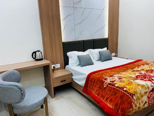 a bedroom with a bed and a desk and a chair at Hotel Rajasthan Inn in Behror