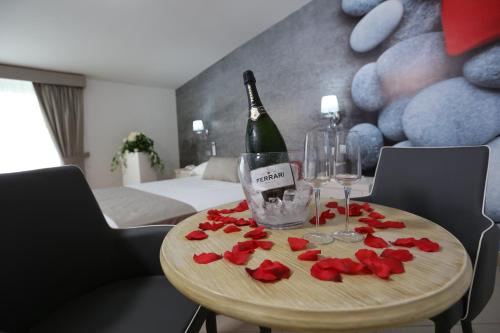 a table with a bottle of wine and roses on it at Medea Resort in Bellona
