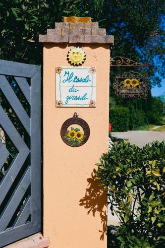 a sign on a wall next to a gate at "IL CASALE DEI GIRASOLI" Country House in Capalbio in Capalbio