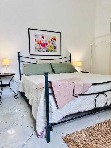 a bedroom with a bed with a picture on the wall at Villa Artemide - Ospitalità nel Borgo in Marsico Vetere