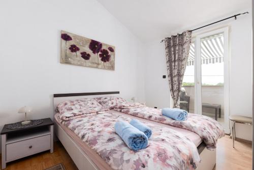 a bedroom with a bed with blue towels on it at Apartman Mely in Nova Vas