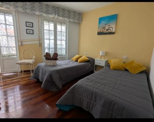 a bedroom with two beds and a bike on the wall at Casa Magua Melide in Melide