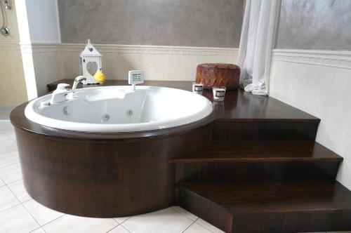 a bath tub in a bathroom with a wooden floor at La CASA DI OLIVER in Pian Camuno