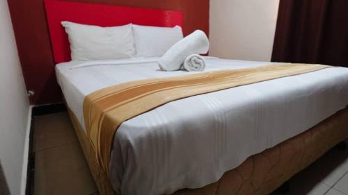 a bedroom with a large bed with a red headboard at HWKl in Kuala Lumpur