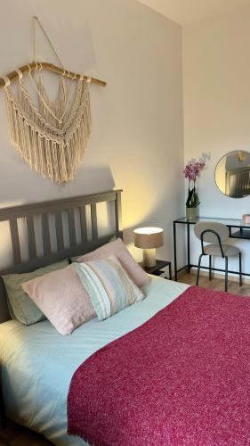 a bedroom with a large bed with a pink blanket at Apartament Wichrowy in Rowy