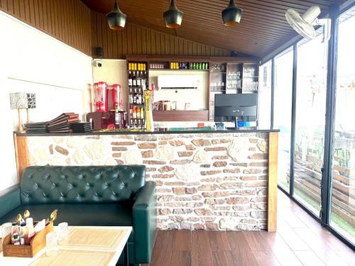 a bar with a green couch in front of a counter at Hotel Lotus castle in Bathinda